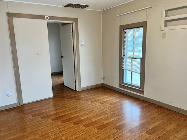 unfurnished room with wood-type flooring