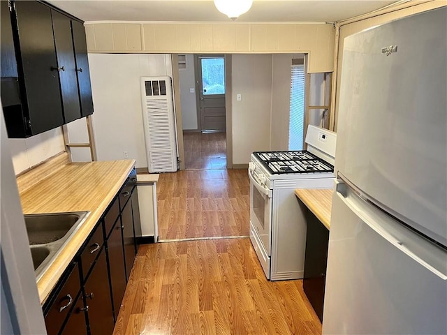 kitchen with stainless steel refrigerator, white gas range, sink, and light hardwood / wood-style flooring