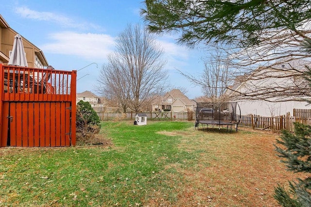 view of yard with a wooden deck and a trampoline