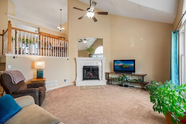 carpeted living room with a tile fireplace, baseboards, visible vents, and high vaulted ceiling