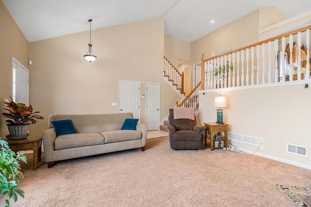 carpeted living area featuring visible vents, baseboards, high vaulted ceiling, and stairway