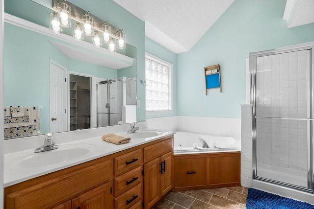 full bath featuring vaulted ceiling, a stall shower, a textured ceiling, and a sink