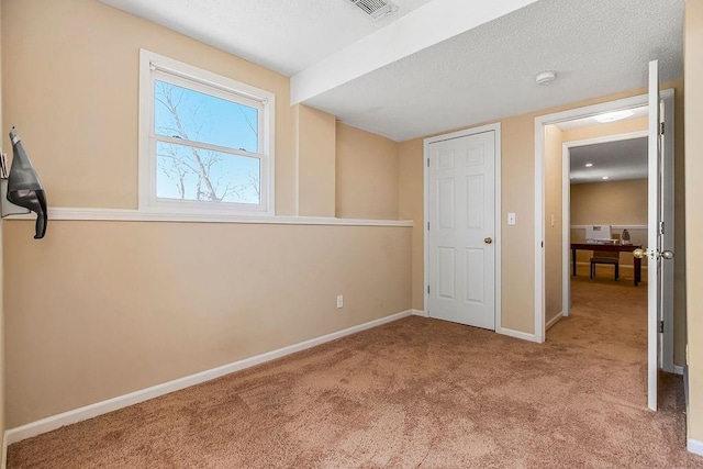 unfurnished bedroom featuring visible vents, baseboards, carpet, and a textured ceiling