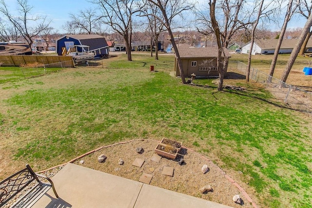 view of yard featuring a residential view, an outdoor structure, and fence