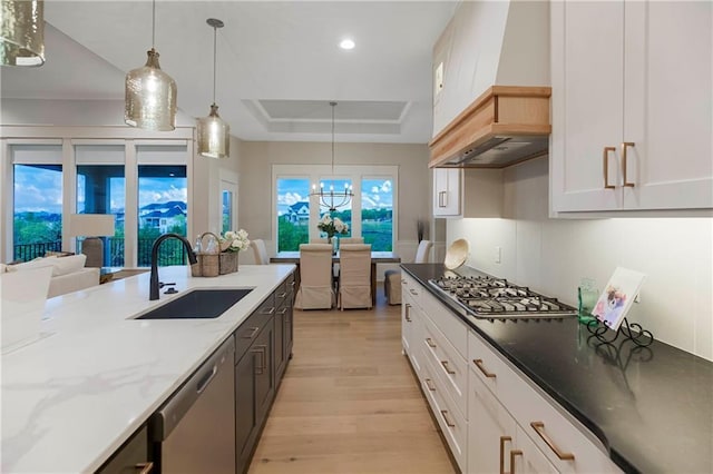 12505 W 184th St, Overland Park, KS 66013 - kitchen with stainless steel appliances, custom exhaust hood, a raised ceiling, light wood-style floors, and white cabinetry