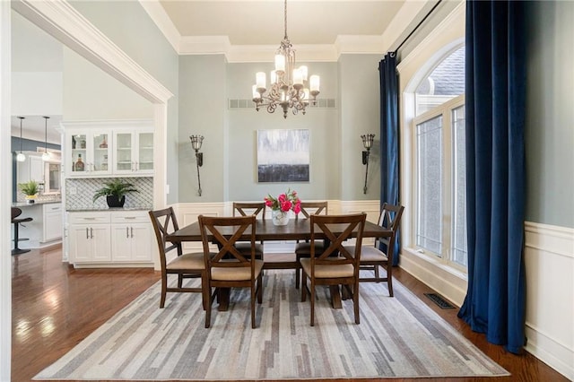 dining space featuring visible vents, a wainscoted wall, and light wood-type flooring