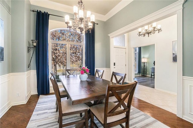 dining room featuring an inviting chandelier, wood finished floors, and wainscoting