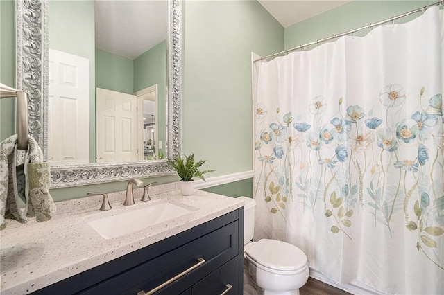 bathroom with curtained shower, toilet, and vanity