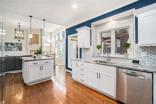 kitchen with light stone countertops, a sink, dark wood-type flooring, white cabinets, and dishwasher