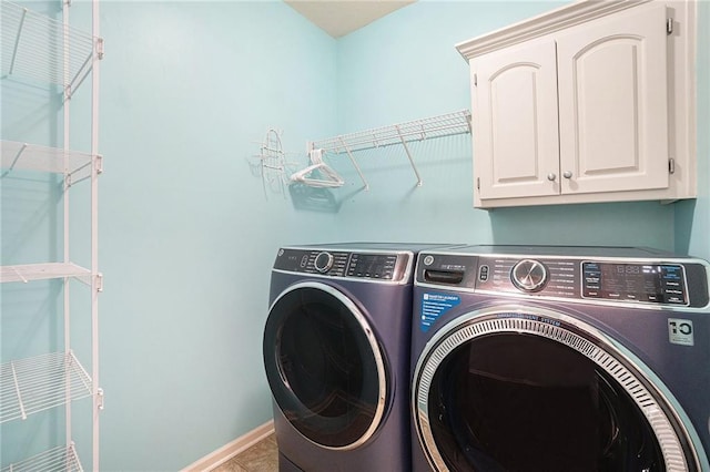 washroom with washing machine and clothes dryer, tile patterned flooring, cabinet space, and baseboards