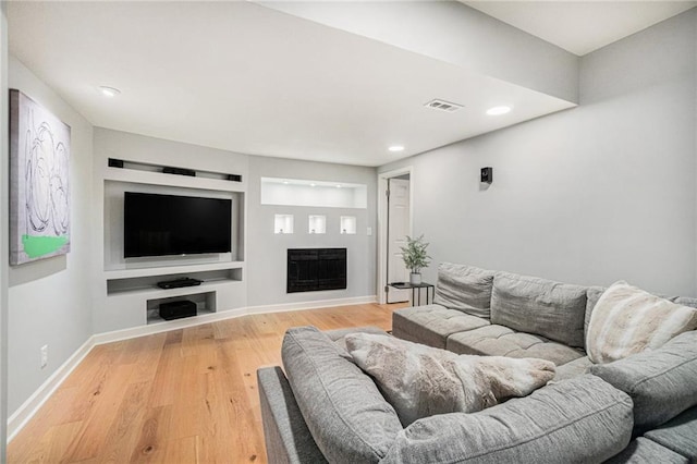 living room featuring visible vents, light wood-style flooring, recessed lighting, a fireplace, and baseboards