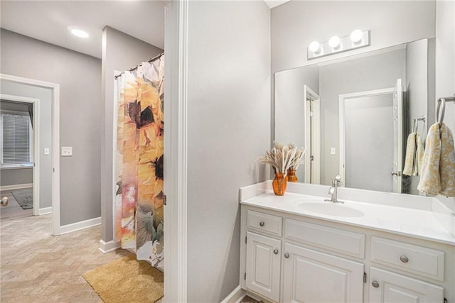 bathroom with a shower with shower curtain, baseboards, and vanity