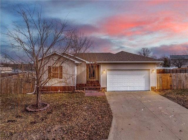 ranch-style home with a garage, driveway, and fence