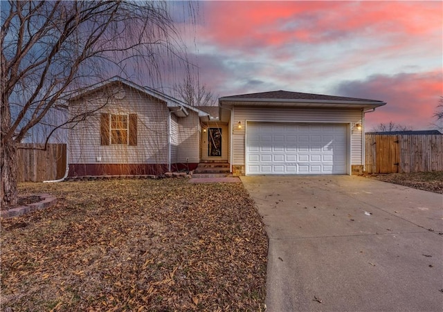 single story home with an attached garage, fence, and concrete driveway