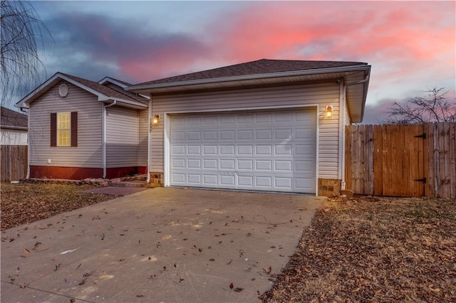 exterior space with a garage, concrete driveway, and fence