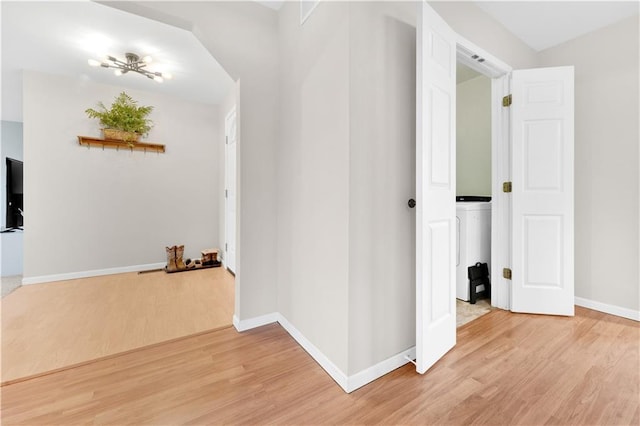 hallway with light wood-type flooring and baseboards