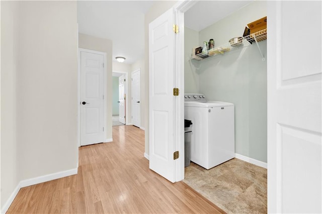 laundry area with light wood-style floors, baseboards, laundry area, and washer / clothes dryer