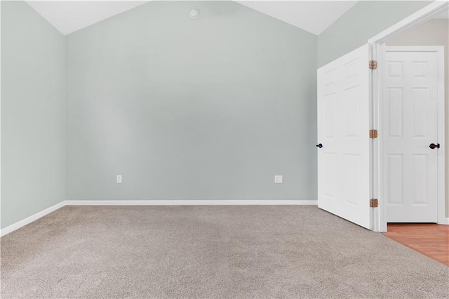 unfurnished bedroom with vaulted ceiling, carpet, and baseboards