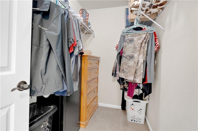 walk in closet featuring light colored carpet