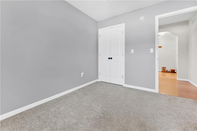 unfurnished bedroom featuring a closet, carpet flooring, and baseboards