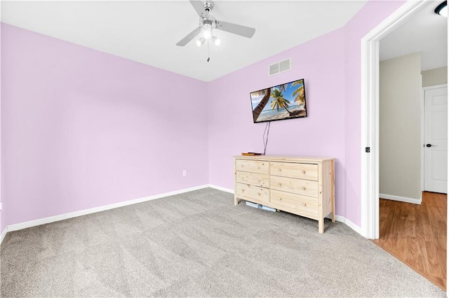 unfurnished bedroom featuring carpet floors, baseboards, visible vents, and a ceiling fan