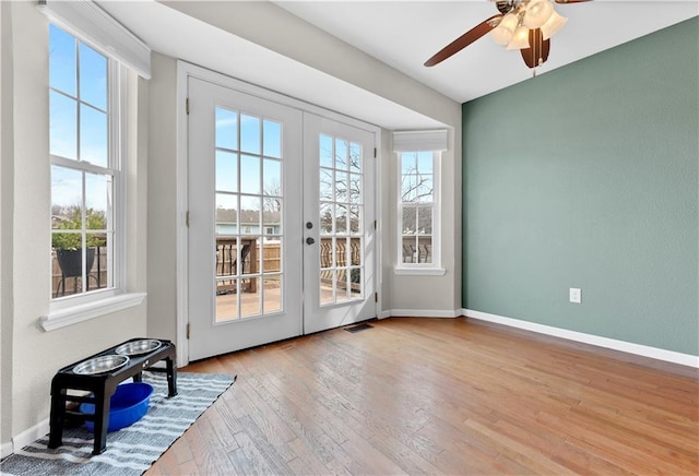 doorway with a healthy amount of sunlight, hardwood / wood-style flooring, baseboards, and french doors