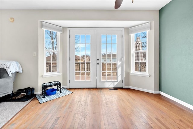 doorway with visible vents, hardwood / wood-style flooring, a wealth of natural light, and baseboards