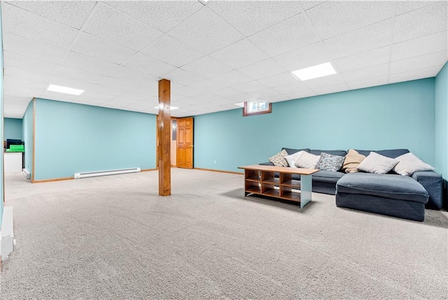 carpeted living room featuring a baseboard heating unit, a paneled ceiling, and baseboards