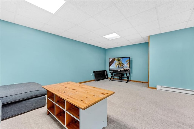 interior space featuring a paneled ceiling, a baseboard radiator, and baseboards