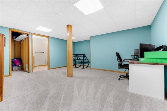 carpeted office space with a paneled ceiling and baseboards