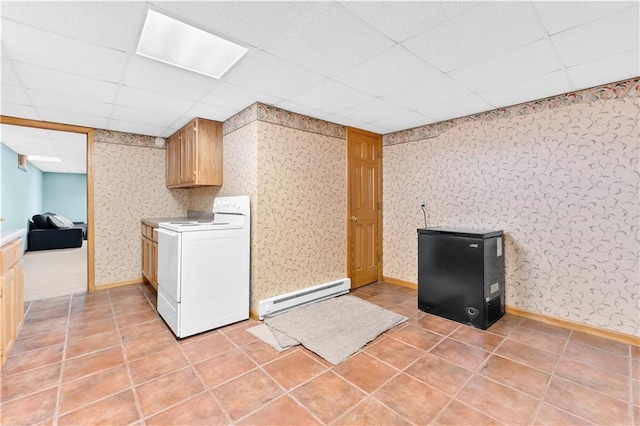 laundry room featuring light tile patterned floors, a baseboard radiator, laundry area, washer / dryer, and wallpapered walls