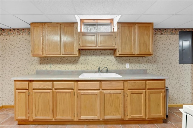 kitchen featuring light countertops, electric panel, a sink, and wallpapered walls