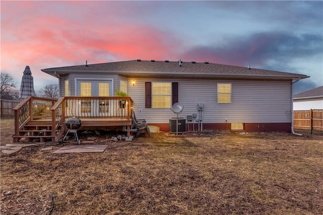 rear view of house with central AC, fence, and a deck