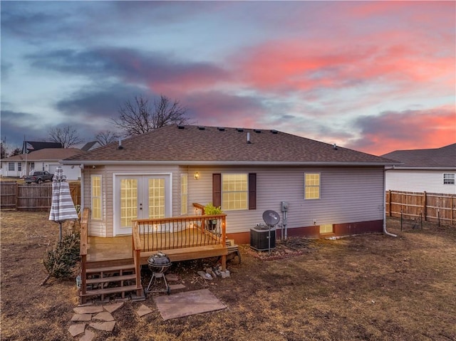 back of house featuring a fenced backyard, a deck, cooling unit, and roof with shingles