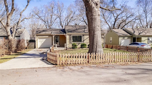 single story home featuring a fenced front yard, an attached garage, and driveway