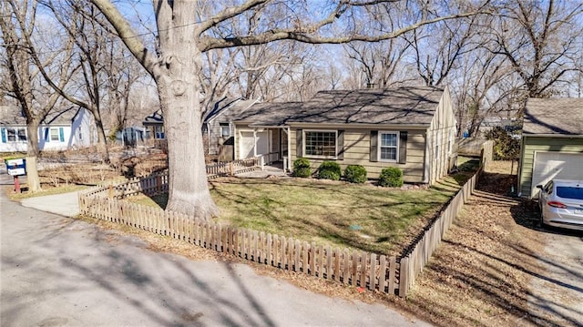 ranch-style home with a front lawn, a garage, and a fenced front yard