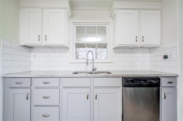 kitchen featuring a sink, light stone counters, white cabinets, decorative backsplash, and dishwasher