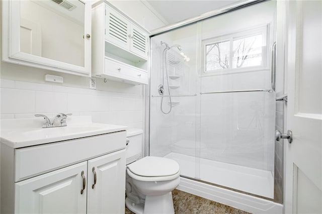 bathroom featuring visible vents, toilet, tile walls, and a shower stall