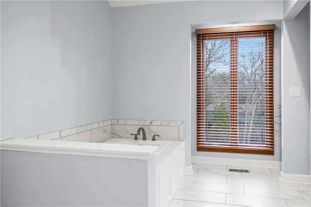 bathroom with visible vents, marble finish floor, a wealth of natural light, and baseboards