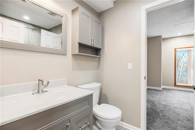 bathroom featuring vanity, toilet, and baseboards