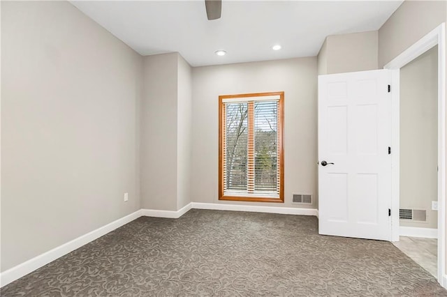 unfurnished room with baseboards and visible vents