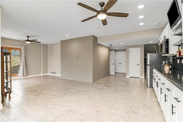 kitchen featuring a ceiling fan, recessed lighting, freestanding refrigerator, white cabinetry, and dark countertops