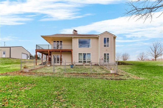 rear view of property featuring a lawn, fence private yard, a chimney, and a garage