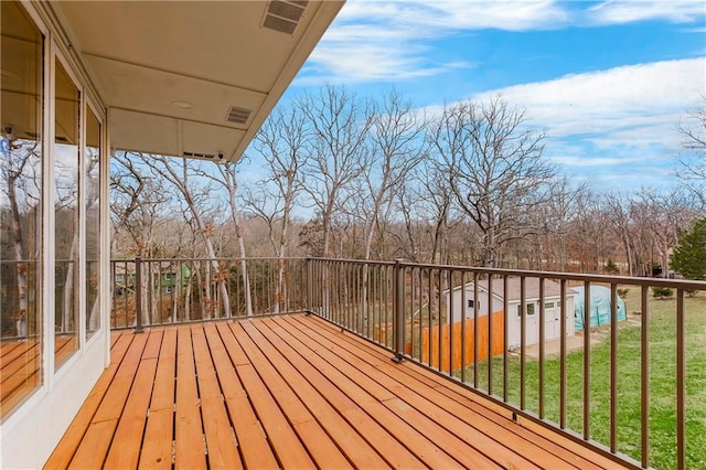 deck featuring visible vents and a lawn