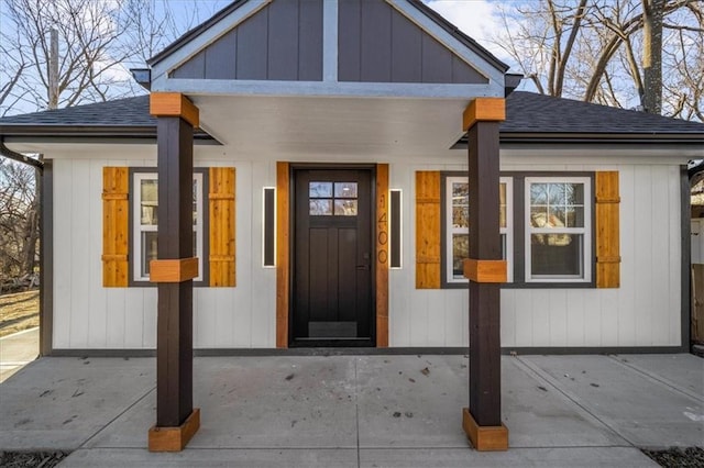 property entrance with board and batten siding and roof with shingles