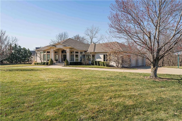 view of front of property featuring a garage, a front yard, driveway, and stucco siding