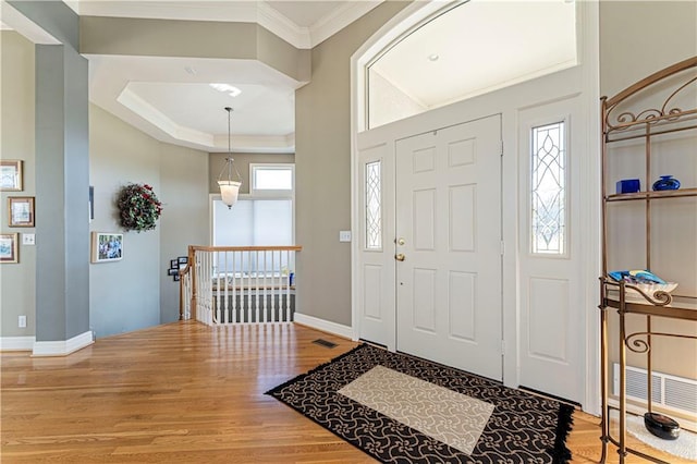 entrance foyer with crown molding, light wood-style flooring, and baseboards