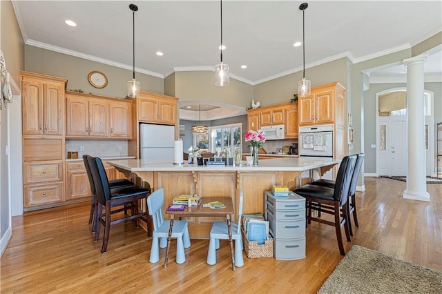 kitchen with white appliances, light wood-style floors, light countertops, and ornate columns