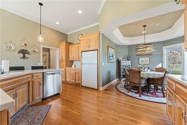 kitchen featuring pendant lighting, stainless steel dishwasher, freestanding refrigerator, light wood finished floors, and light countertops