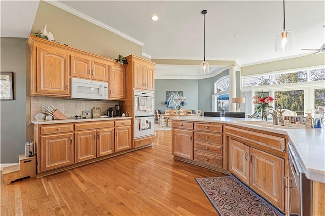 kitchen with crown molding, light countertops, decorative backsplash, light wood-style flooring, and white appliances